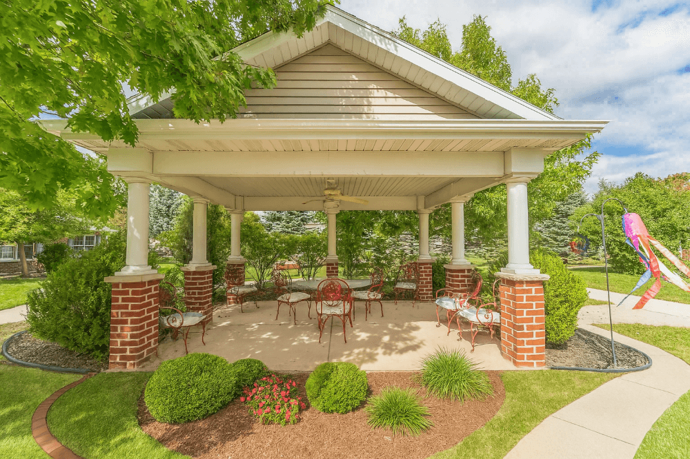 Charming gazebo with outdoor seating in lush garden.