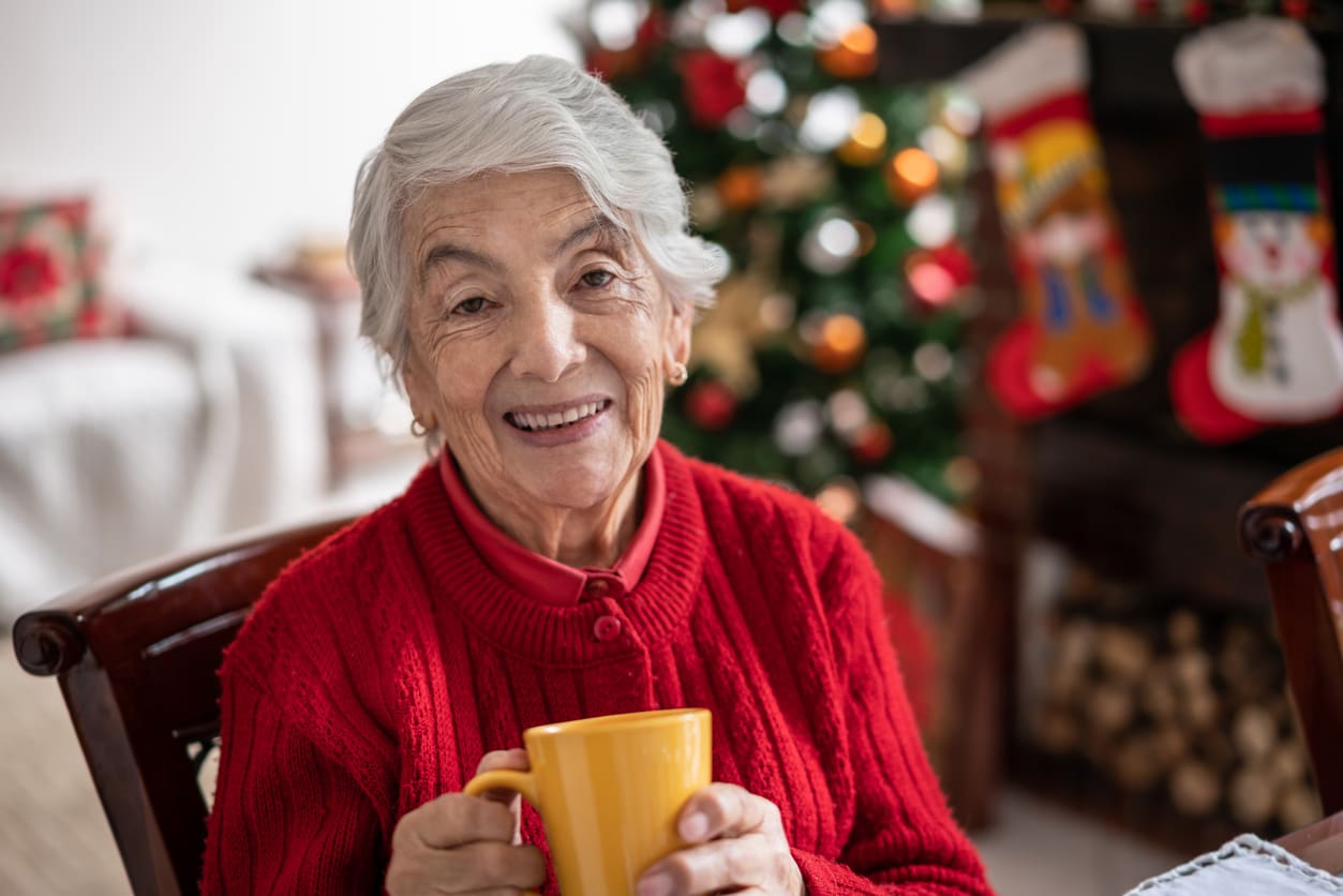 Latin American beautiful senior woman at home enjoying a cup of hot chocolate on a joyful Christmas day - Christmas celebration concepts
