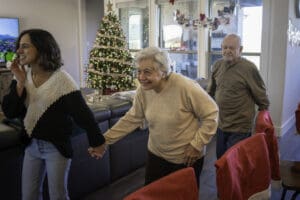 woman leads grandmother with dementia through her home in Prosper, TX during the holidays