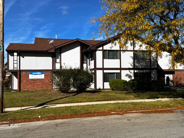 Two-story brick and wood building with sign.